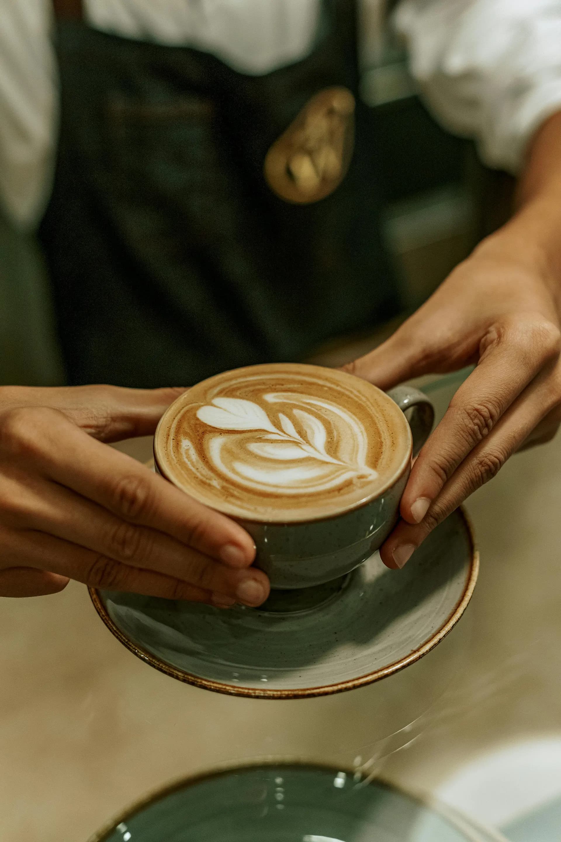 Barista sirviendo cappuccino con arte latte